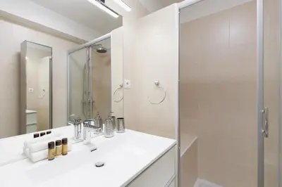 a bathroom with a white sink and a shower at Phoenix YourHostHelper in Cannes