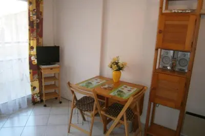 a small table and chairs in a room with a television at Comfortable Flat With Balcony Cannes City Centre in Cannes