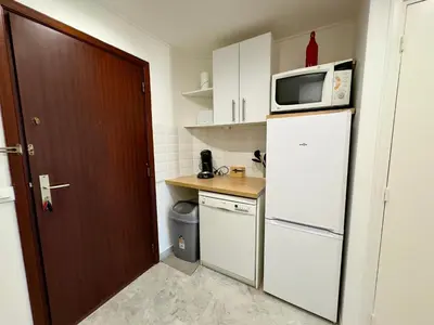 a small kitchen with a white refrigerator and a microwave at L'Alexandra By SCLS Locations in Cannes