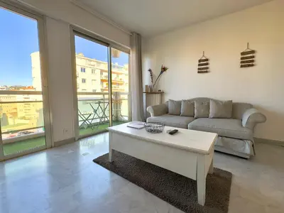 a living room with a couch and a coffee table at L'Alexandra By SCLS Locations in Cannes