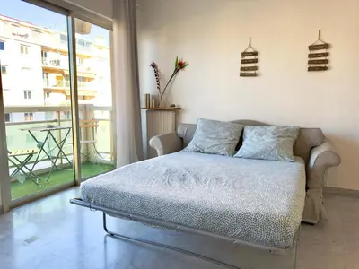 a bedroom with a bed and a large window at L'Alexandra By SCLS Locations in Cannes