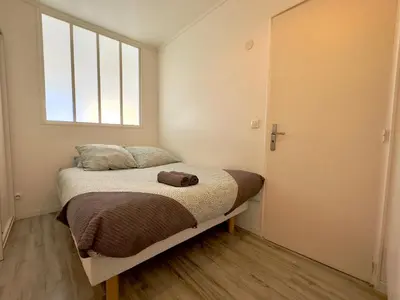a small bedroom with a bed with a window at L'Alexandra By SCLS Locations in Cannes