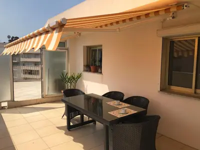 a table and chairs on a patio with awning at Esterel Terrasses, roof top front de mer, parking payant in Cannes