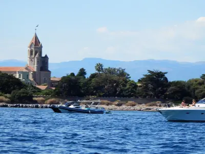 three boats in the water with a church in the background at Esterel Terrasses, roof top front de mer, parking payant in Cannes