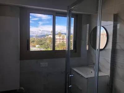 a bathroom with a glass shower and a window at Esterel Terrasses, roof top front de mer, parking payant in Cannes
