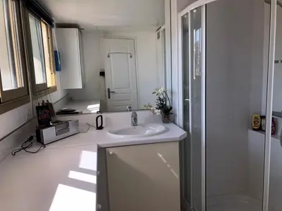 a white bathroom with a sink and a shower at Esterel Terrasses, roof top front de mer, parking payant in Cannes