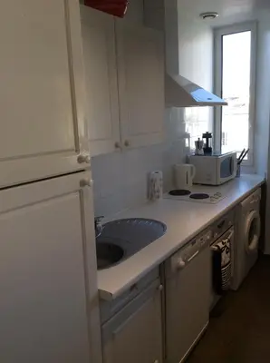 a white kitchen with a sink and a microwave at Lecerf apartment in Cannes