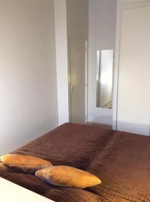 a bedroom with two pillows on a bed with a mirror at Lecerf apartment in Cannes