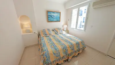 a bedroom with a bed and a window at Ref ILES - Palmes d'Or Properties in Cannes