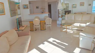 a living room with a couch and a table and chairs at Ref ILES - Palmes d'Or Properties in Cannes