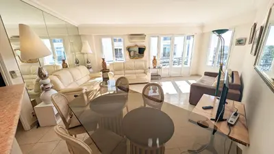 a living room with a glass table and chairs at Ref ILES - Palmes d'Or Properties in Cannes