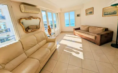 a living room with a couch and a mirror at Ref ILES - Palmes d'Or Properties in Cannes