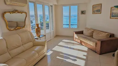 a living room with two couches and a mirror at Ref ILES - Palmes d'Or Properties in Cannes