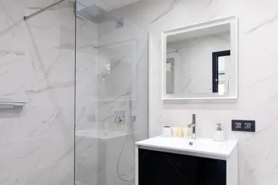 a white bathroom with a sink and a shower at Cannes CROISETTE, Palais des Festivals, Beaches, Apart Residence Le MINERVE in Cannes
