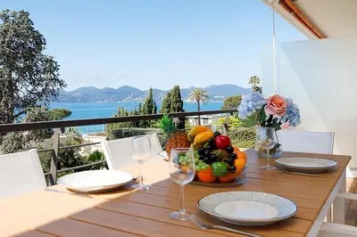 a wooden table with a bowl of fruit and wine glasses at Suite Riviera - Sea View - Clim - 50M Plage - Residence de standing - Spacieux 180 M2 - Parking in Cannes