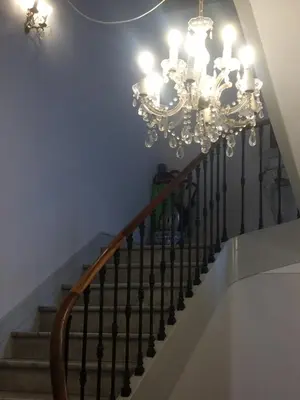 a staircase with a chandelier in a house at Au petit Marius in Cannes