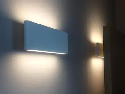 a flat screen tv on a wall with two lights at Au petit Marius in Cannes
