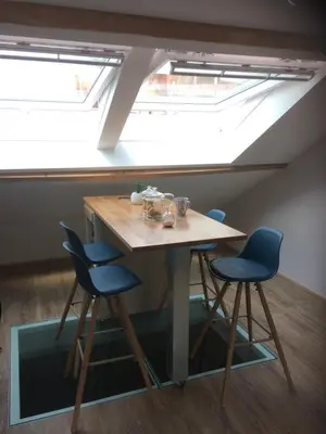 a table and two chairs in a room with a skylight at Au petit Marius in Cannes