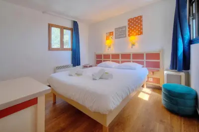 a bedroom with a large bed and a blue chair at IMMOGROOM - sea view - Pool - Terrace - Parking - Wifi - AC in Cannes