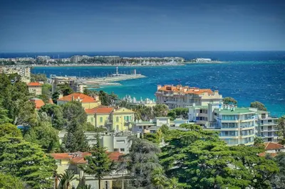 a city with houses and the ocean and a pier at IMMOGROOM - sea view - Pool - Terrace - Parking - Wifi - AC in Cannes