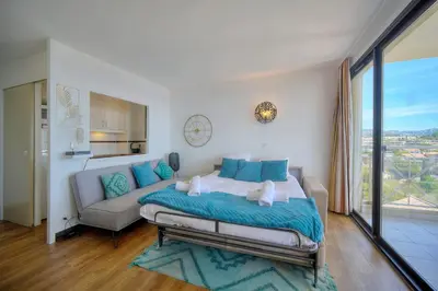 a bedroom with a large bed and a couch at IMMOGROOM - sea view - Pool - Terrace - Parking - Wifi - AC in Cannes