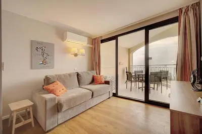 a living room with a couch and a table at IMMOGROOM - 2 Rooms sea view - Swimming pool - Terrace - Parking - AC in Cannes