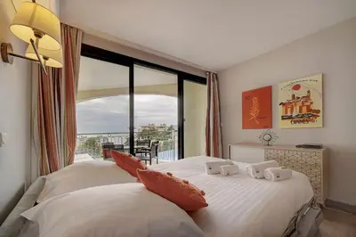 a bedroom with two beds and a large window at IMMOGROOM - 2 Rooms sea view - Swimming pool - Terrace - Parking - AC in Cannes