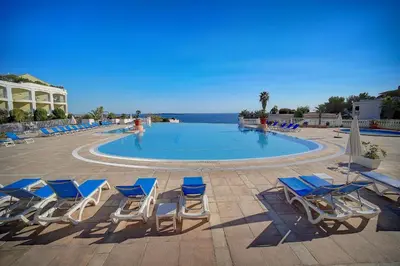 a group of chairs and a swimming pool with the ocean at IMMOGROOM - 2 Rooms sea view - Swimming pool - Terrace - Parking - AC in Cannes