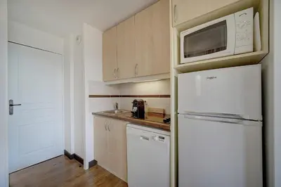 a kitchen with a white refrigerator and a microwave at IMMOGROOM - 2 Rooms - Renovated - Pool - Parking - Air conditioning - in Cannes