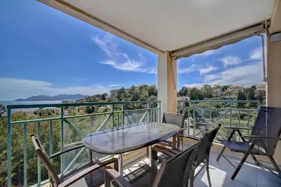 a balcony with a table and chairs and a view at IMMOGROOM - 2 Rooms - Renovated - Pool - Parking - Air conditioning - in Cannes