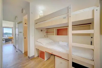 a bedroom with two bunk beds and a hallway at IMMOGROOM - 2 Rooms - Renovated - Pool - Parking - Air conditioning - in Cannes
