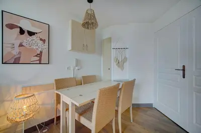 a dining room with a white table and chairs at IMMOGROOM - 2 Rooms renovated - Pool - Terrace - Garden - Parking - in Cannes