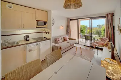 a kitchen and living room with a couch and a table at IMMOGROOM - 2 Rooms renovated - Pool - Terrace - Garden - Parking - in Cannes