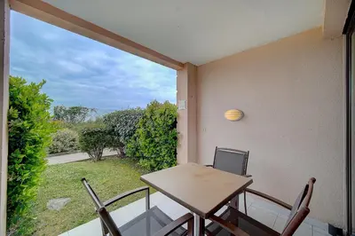 a table and chairs on a balcony with a view at IMMOGROOM - 2 Rooms renovated - Pool - Terrace - Garden - Parking - in Cannes