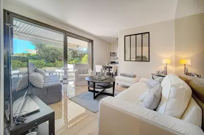 a living room with white furniture and a large window at IMMOGROOM - Close beaches - Terrace with sea view - pool -AC in Cannes