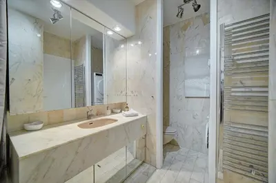 a bathroom with a sink and a mirror and a toilet at IMMOGROOM - Close beaches - Terrace with sea view - pool -AC in Cannes