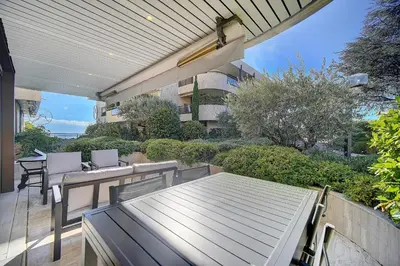 a patio with a table and chairs and a building at IMMOGROOM - Close beaches - Terrace with sea view - pool -AC in Cannes