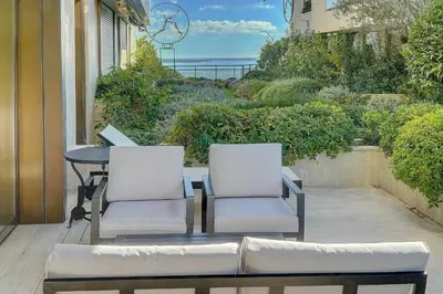 two chairs and a table on a balcony with the ocean at IMMOGROOM - Close beaches - Terrace with sea view - pool -AC in Cannes