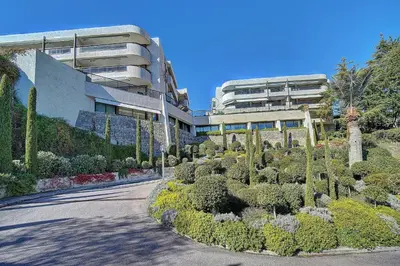 a building with a garden in front of a building at IMMOGROOM - Close beaches - Terrace with sea view - pool -AC in Cannes