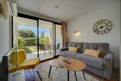 a living room with a couch and a table at IMMOGROOM - 2 Rooms - Pool - Garden - Terrace - Parking - AC in Cannes