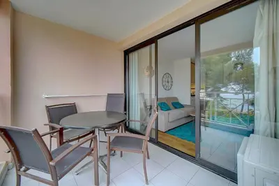 a dining room with a table and chairs and a living room at IMMOGROOM - 2 Rooms - Renovated - Pool - Air conditioning - Parking - Wifi in Cannes