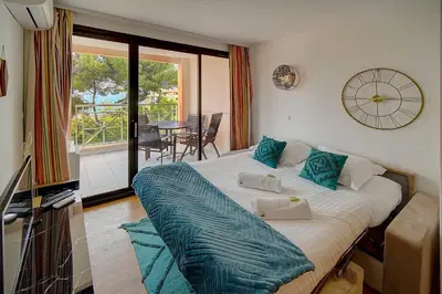 a bedroom with a bed with a clock on the wall at IMMOGROOM - 2 Rooms - Renovated - Pool - Air conditioning - Parking - Wifi in Cannes