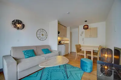 a living room with a couch and a table at IMMOGROOM - 2 Rooms - Renovated - Pool - Air conditioning - Parking - Wifi in Cannes