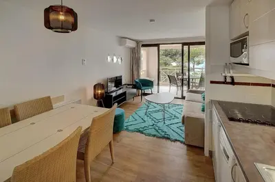 a kitchen and living room with a table and chairs at IMMOGROOM - 2 Rooms - Renovated - Pool - Air conditioning - Parking - Wifi in Cannes