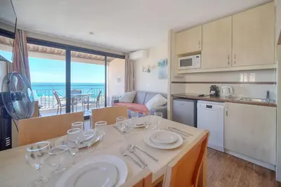 a kitchen with a table with wine glasses on it at IMMOGROOM - 2 Rooms sea view - Swimming pool - Terrace - Parking - AC in Cannes