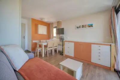 a living room with a couch and a table at IMMOGROOM - 2 Rooms sea view - Swimming pool - Terrace - Parking - AC in Cannes
