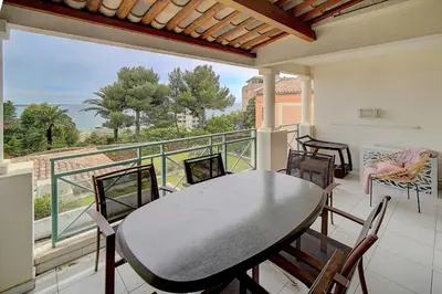 a balcony with a table and chairs and a view of the ocean at IMMOGROOM - 2 Rooms sea view - Renovated - Pool - Terrace - Parking - AC in Cannes