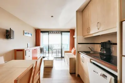 a kitchen with a counter top and a living room at Résidence Cannes Villa Francia - maeva Home - Appartement 3 Pièces 6 Personnes - Confort MAE-7944 in Cannes