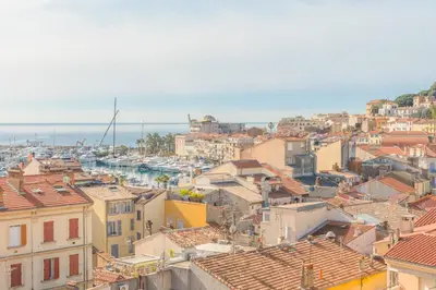 a view of a city with buildings and the ocean at Cannes Stunning sea and old town view for our full comfort 3 BR with balcony by Olam Properties in Cannes