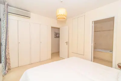 a white bedroom with a bed and a window at Cannes Stunning sea and old town view for our full comfort 3 BR with balcony by Olam Properties in Cannes